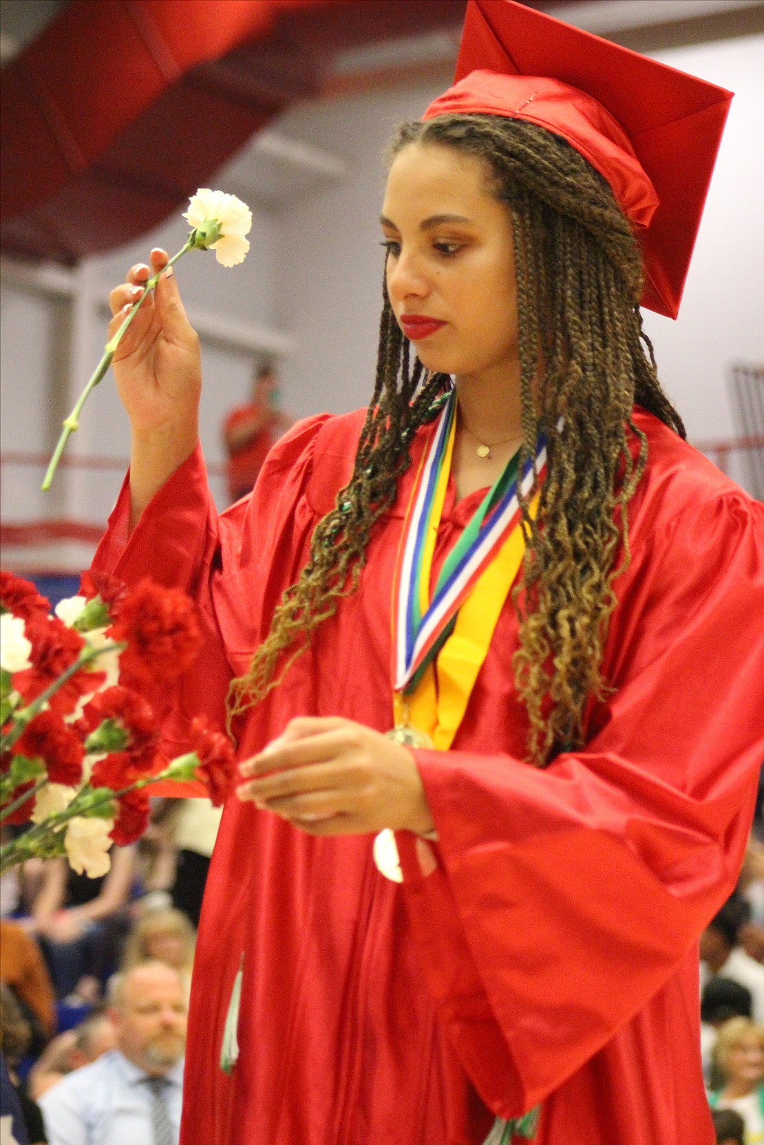 Laila Waddell finds a spot for her carnation in a vase for Jay County High School graduates Sunday. (The Commercial Review/Bailey Cline)