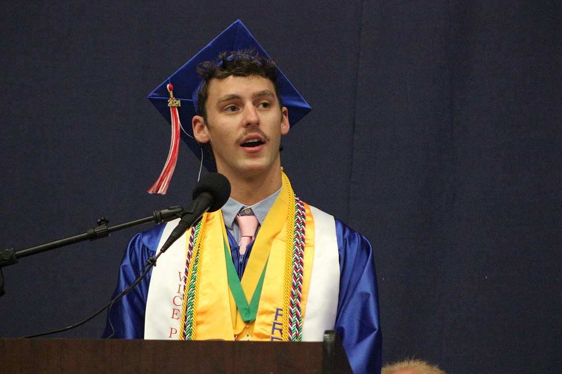 Senior class vice president Nicholas Lyons speaks Sunday during commencement at Jay County High School. “Be rich in love, rich in happiness, rich in friendship and rich in knowledge,” he said. “Live each day in the moment, focusing on the episode you are living right now, because unlike television, there are no re-winds.” (The Commercial Review/Bailey Cline)