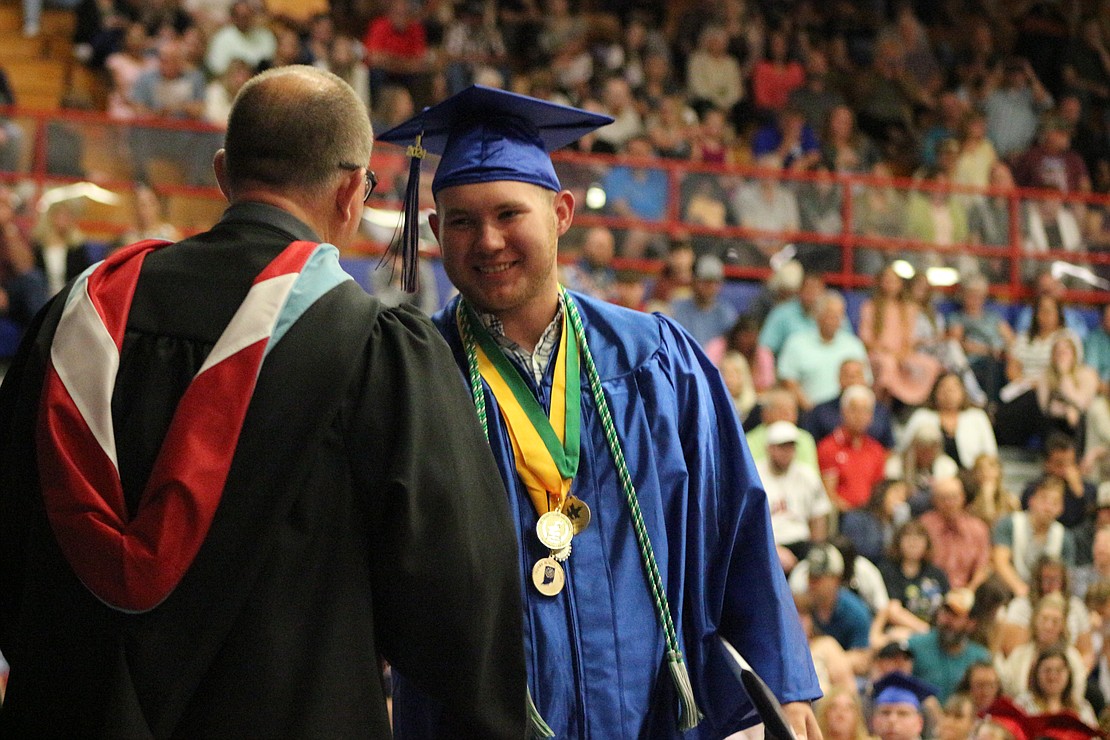 Ryne Goldsworthy shakes hands with Jay County High School principal Chad Dodd after receiving his diploma Sunday. (The Commercial Review/Bailey Cline)