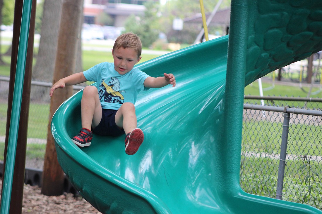 Hunter Muhlenkamp, 5, races down the slide Wednesday at Haynes Park in Portland. Temperatures are expected to hit the high 70s today under sunny skies. (The Commercial Review/Bailey Cline)