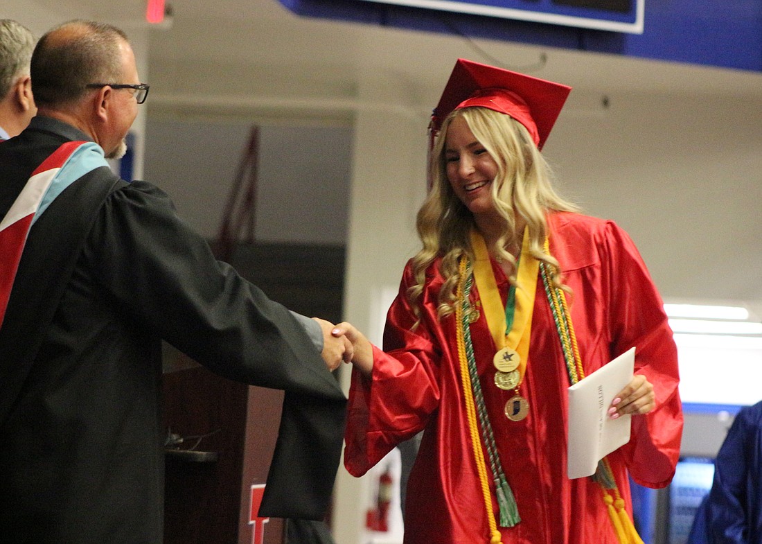 Maggie Dillon shakes hands with Jay County High School principal Chad Dodd on Sunday after receiving her diploma. She was one of 208 students who graduated in the Class of 2024. (The Commercial Review/Bailey Cline)