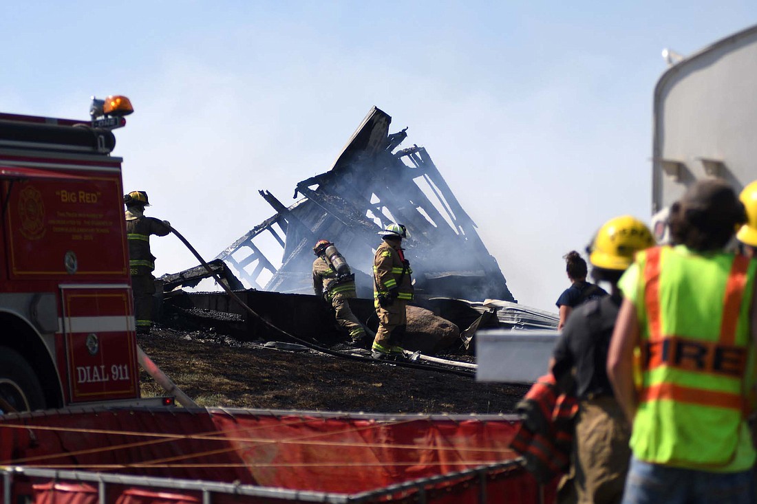 Firefighters work amongst the rubble at the scene of a fire Sunday afternoon at 1620 W. 850 North, rural Ridgeville. The fire destroyed a house and a garage. (The Commercial Review/Ray Cooney)