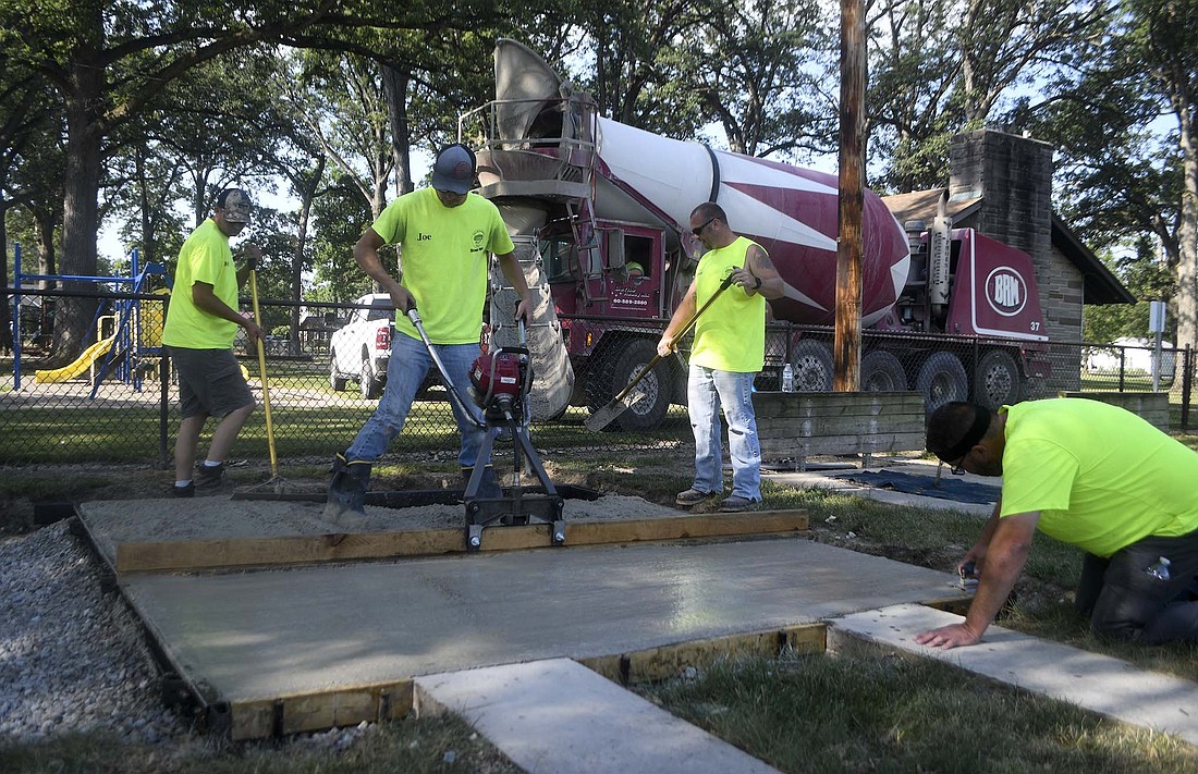 Portland city employees, from left, Kody Muhlenkamp, Joe Jackson and Justin Detro work on installing new cornhole courts at Haynes Park. The courts took the place of a couple of the horseshoe pits at the park. Street and parks department staff also completed mulch work at the park last week. (The Commercial Review/Ray Cooney)