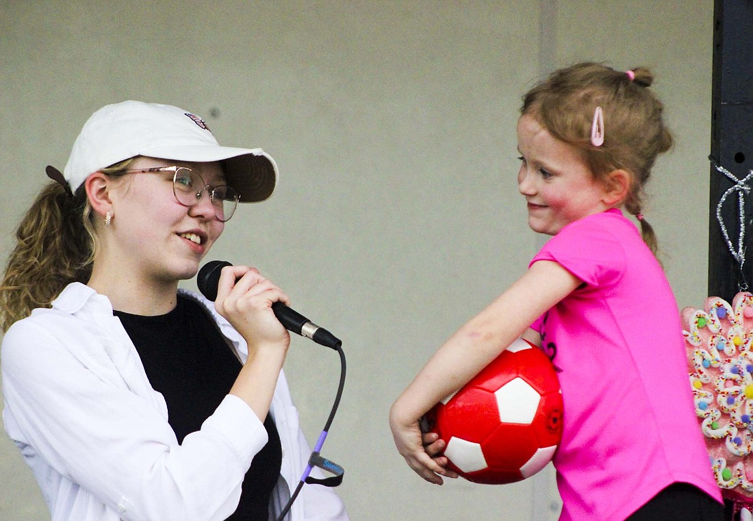 Olivia Smith chats with 4-year-old Ellie Westgerdes during the Little Mr. and Miss of the Fort Recovery Harvest Jubilee contest Thursday at Ambassador Park. Westgerdes dressed up as a soccer player. (The Commercial Review/Bailey Cline)