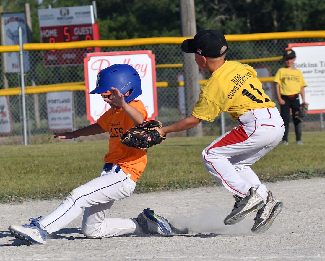 Kipton Zimmerman tags out a runner headed for third base during the Redkey Junior League Minor baseball game between the Hire Construction Pirates and the POET Orioles on Monday. (The Commercial Review/Andrew Balko)