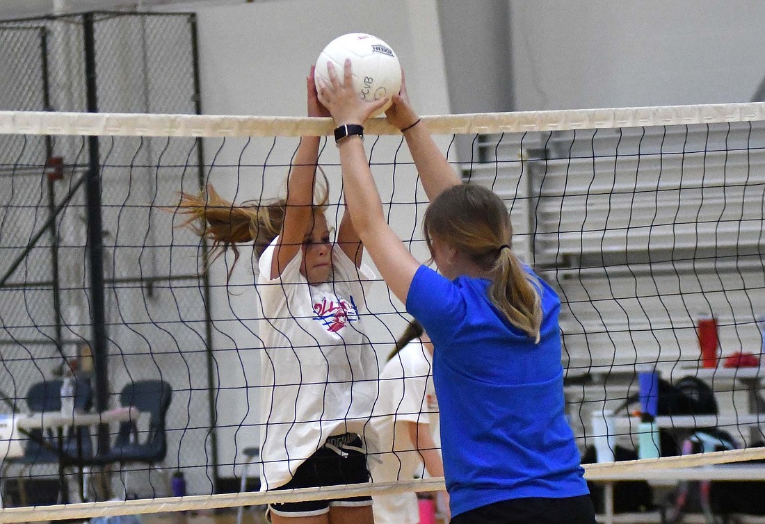 Fifth-grader Elsie Gibbs jumps at the net to simulate a block attempt during a drill Wednesday at the Jay County High School volleyball camp. Students from third to eighth grade met in the auxiliary gym for the three-day camp to learn fundamentals from varsity coach Amy Dillon and high schoolers. (The Commercial Review/Andrew Balko)