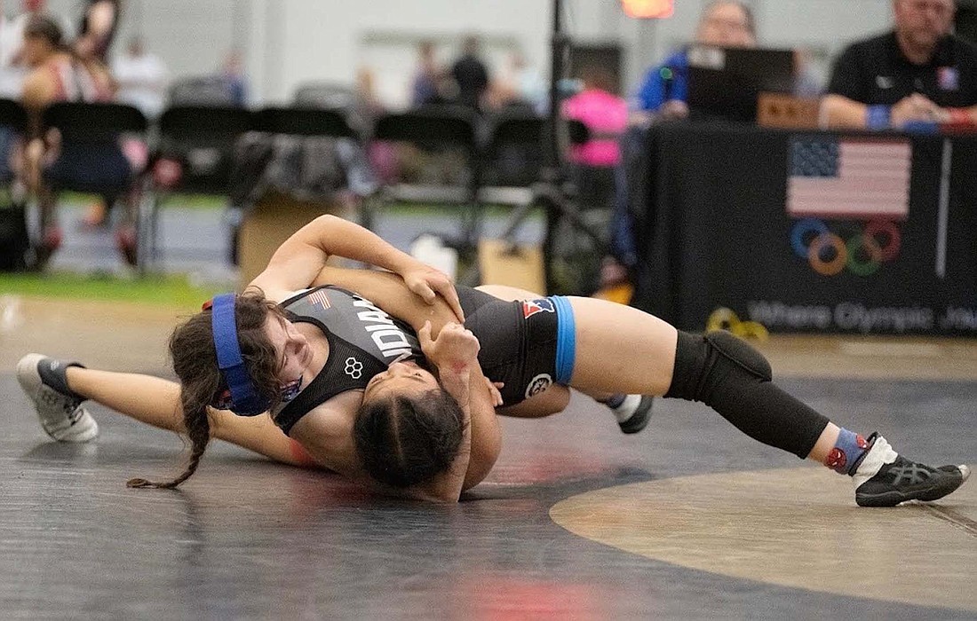 Jay County High School’s Katie Rowles puts Kylee Tran of Oklahoma in a headlock during the USA Women’s Wrestling National Duals in Westfield for Indiana’s 16-and-younger team. Rowles won the match 11-5 and split another pair of matches against Tran throughout the rest of the week. (Special to The Commercial Review/Misty Brown)