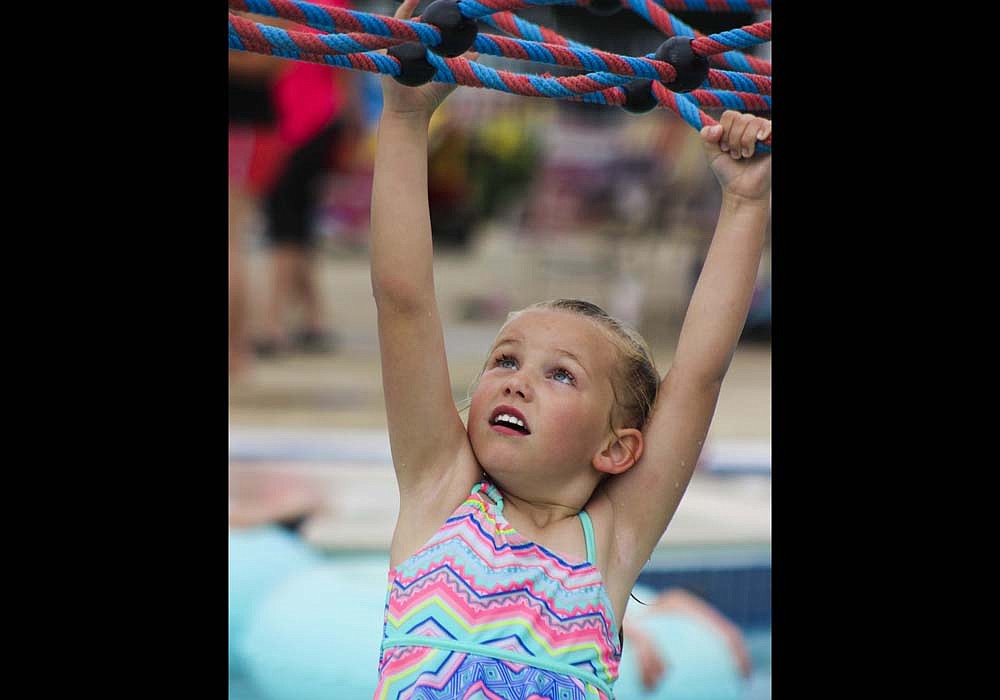 Kassidy Kirby, 5, crosses the lily pad obstacle course Friday during Portland Water Park’s free swim day. The park opened for free to the public from 4 to 8 p.m. Friday, an event sponsored by Southern Thunder Fireworks of Portland. (The Commercial Review/Bailey Cline)