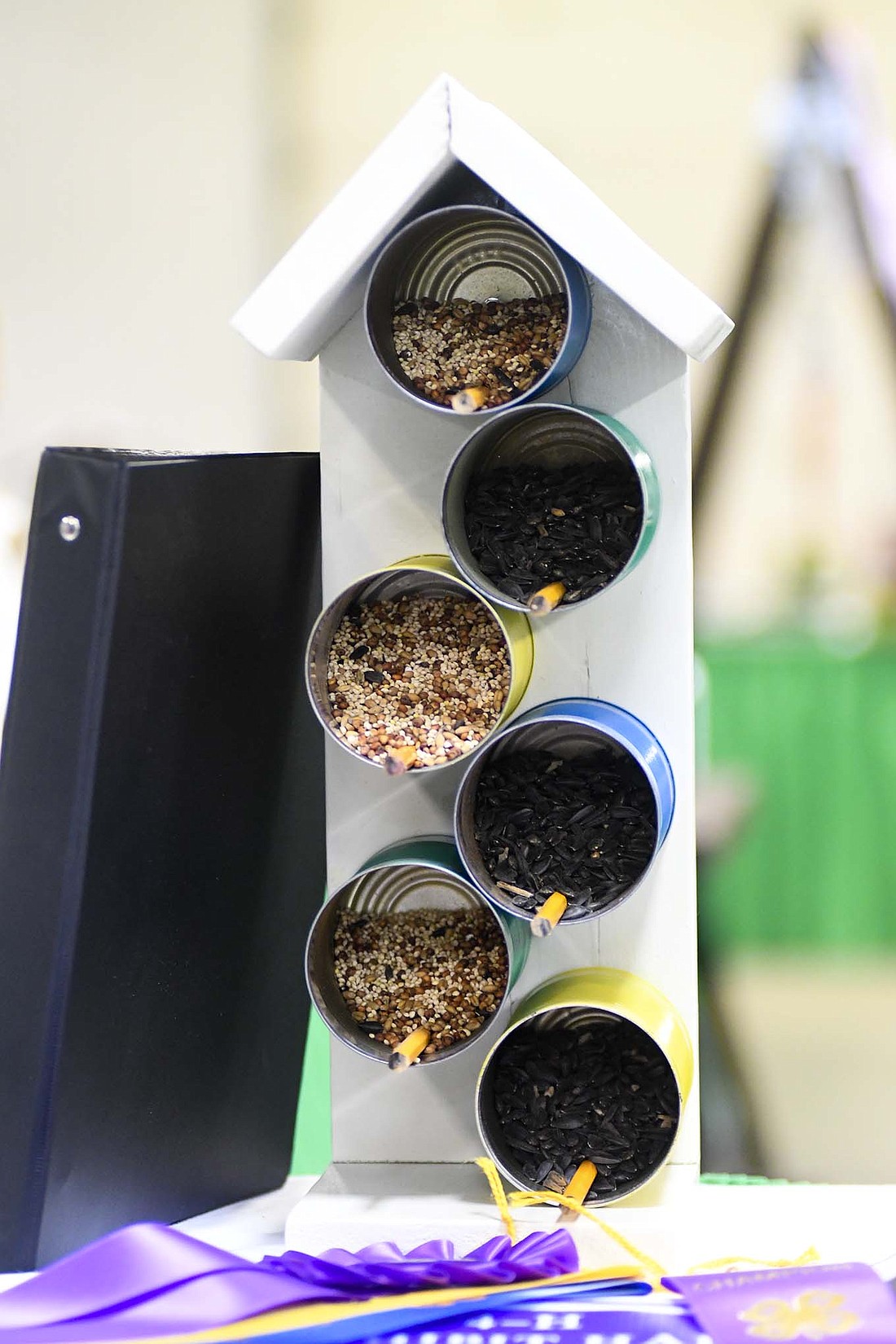 Kenzie Clayton’s winning recycling project at the Jay County Fair features old cans filled with bird feed and pencils as perches for birds to stand on. In addition to being recycling items, the pencils are a safe spot for the birds in the summer months when the cans might get hot. “That won’t get hot, so their little feet won’t get hot,” Clayton said. (The Commercial Review/Ray Cooney)