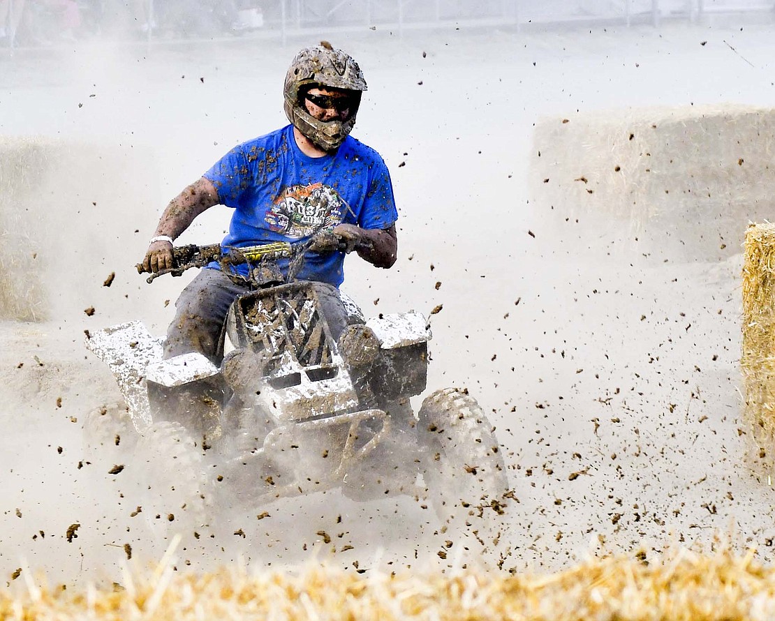 Dirt flies as an ATV rider takes on the first turn during Monday evening’s autocross races at the grandstand. (The Commercial Review/Andrew Balko)