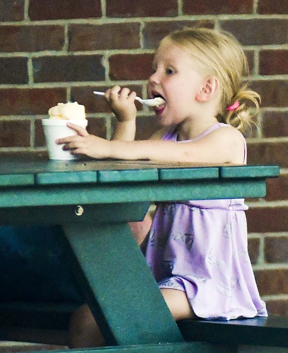 Emma Harrison eats some ice cream next to the Bubp Building during the evening Monday. (The Commercial Review/Andrew Balko)