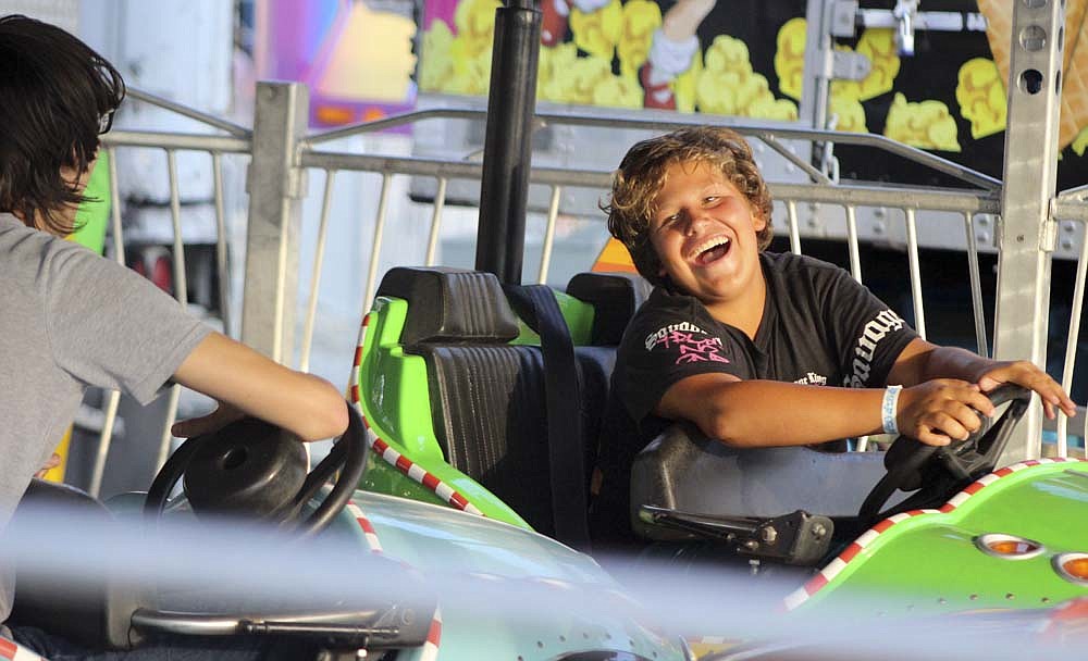 Jorge Valdez, 13, laughs as he crashes into friends Wednesday on Scooter, the bumper car ride on the midway at the Jay County Fair. (The Commercial Review/Bailey Cline)