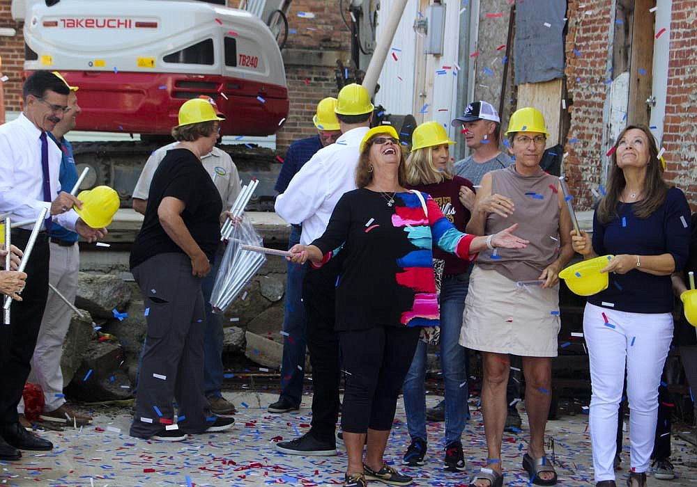 Karen Meiring looks up as confetti falls around her Friday during a groundbreaking ceremony for Fort Recovery Morvilius Opera House. Renovation work on the 141-year-old building is scheduled to begin in the next couple of weeks. (The Commercial Review/Bailey Cline)