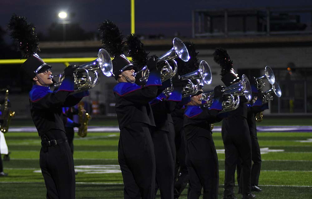 The Jay County High School Marching Patriots placed fifth in Saturday’s Spirit of Sound contest at Muncie Central. Pictured above, the baritone section, including Joseph Boggs (left) and Jensen Avery (second from left) march across the field Saturday night. Below, Cierra Smith whips a king-themed flag over her head. JCHS scored 65.65 points to trail Muncie Central (73.325), Kokomo, Anderson and Richmond. (The Commercial Review/Ray Cooney)