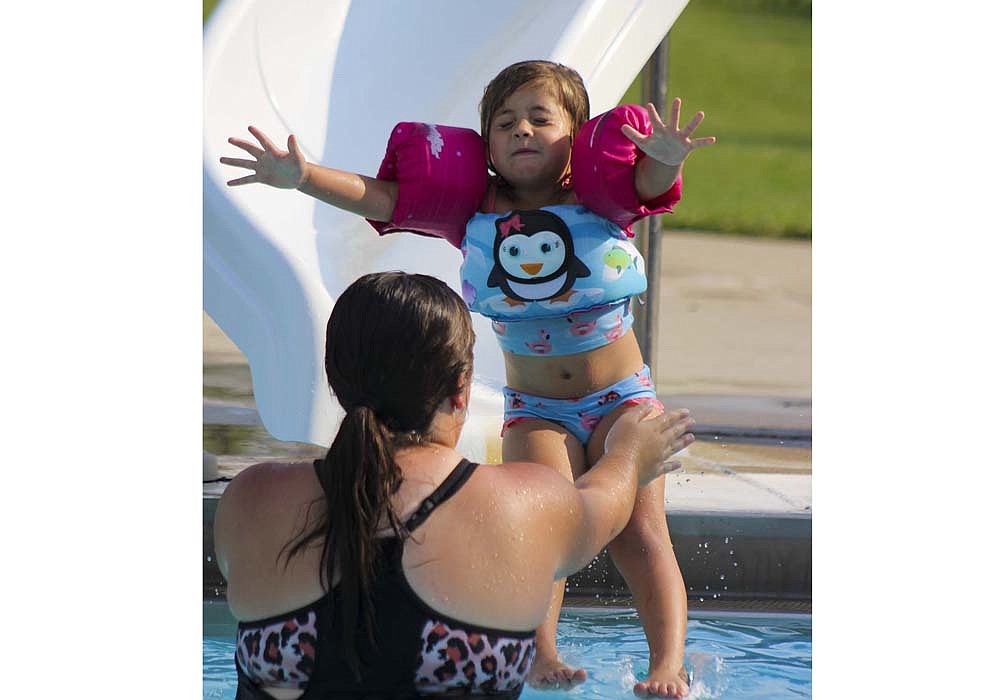 Remi Chilcoat, 4, jumps into the arms of her aunt Kiera Stump during Fort Recovery’s National Night Out festivities Sunday at Ambassador Pool. (The Commercial Review/Bailey Cline)