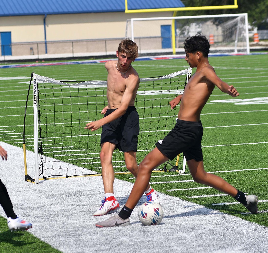 Cayden Buckland gets a through ball past Aryan Montes during the Jay County High School boys soccer pre-season practice on Monday afternoon. Buckland finished last season with two goals scored. (The Commercial Review/Andrew Balko)