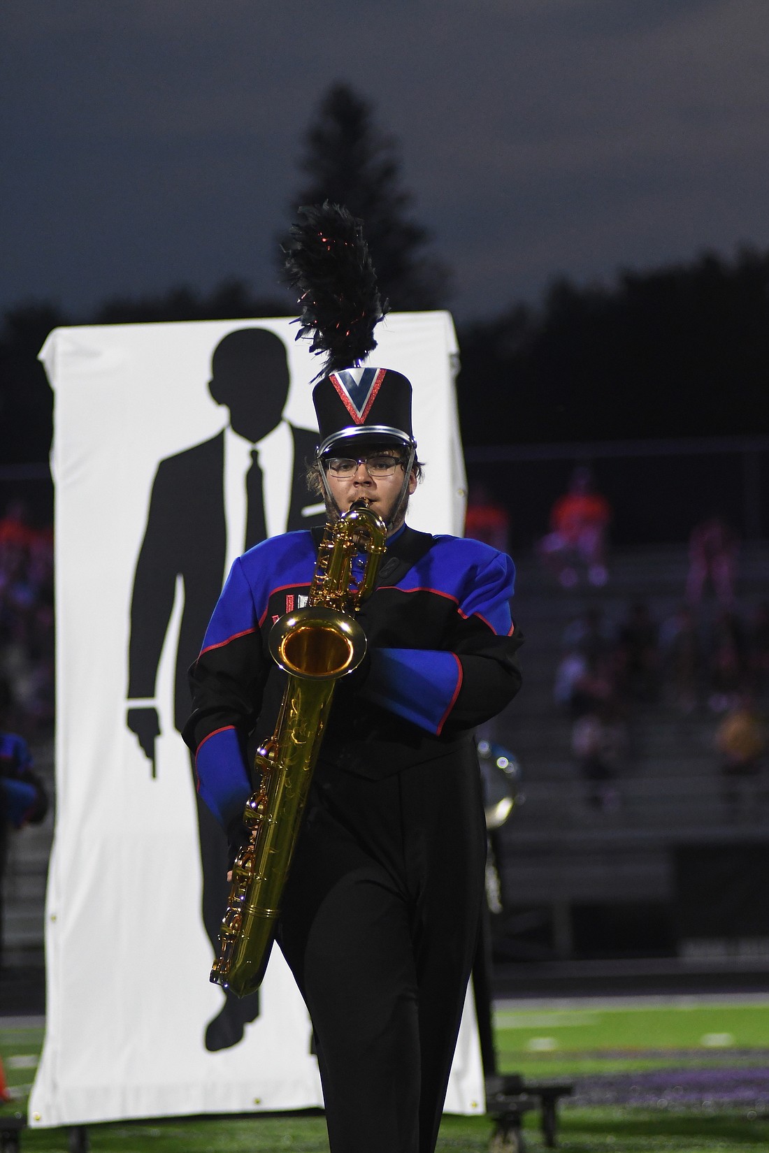 Noah Walter of the Jay County High School Marching Patriots plays the baritone saxophone, with a silhouette of James Bond looking over his shoulder, during Saturday’s Spirit of Sound band contest at Muncie Central High School. JCHS finished fifth in the contest, trailing Muncie Central, Kokomo, Anderson and Richmond. The Marching Patriots, who are at band camp this week, will return for the Drums at Winchester on Saturday. The competition that features 23 bands will begin at 7 p.m. with Jay County scheduled to take the field at 9:53 p.m. (The Commercial Review/Ray Cooney)