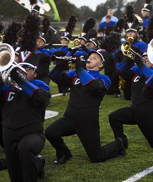 The Jay County High School Marching Patriots, including clarinet player Gina Ward (center) kneel near the end of the first run of their state fair preview show Tuesday evening. The Indiana State Fair Band Day competition begins at 9 a.m. Friday, with JCHS scheduled to take the track at 10:21 a.m. Preliminary awards are at 4:30 p.m., with finals at 8 p.m. (The Commercial Review/Ray Cooney)