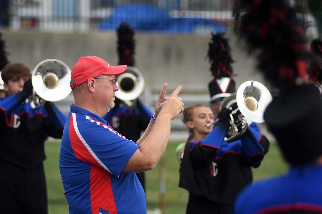 Marching Patriots director Chuck Roesch gives some instructions to his band while warming up prior to their preliminary performance Friday morning. (The Commercial Review/Ray Cooney)