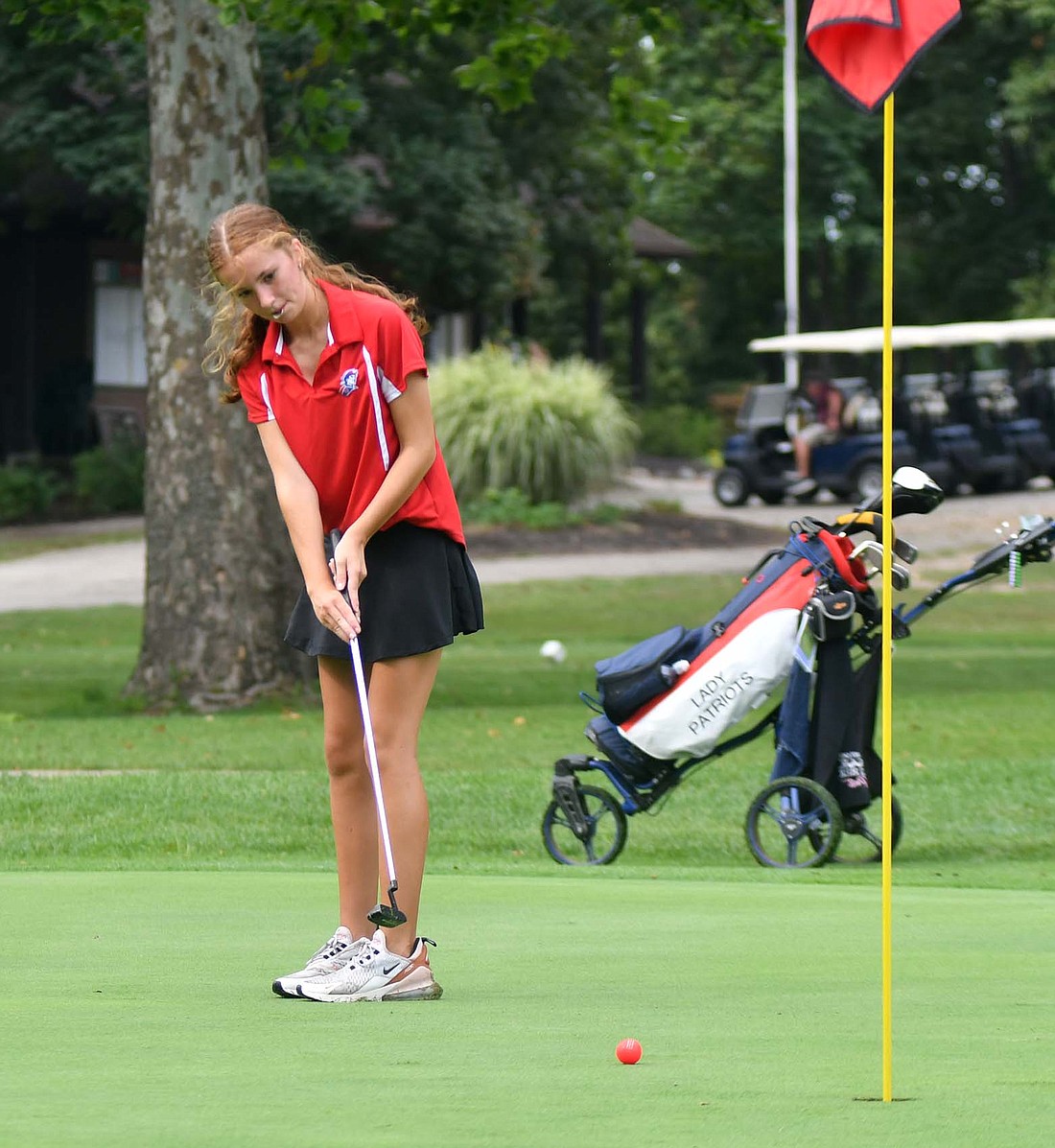 Jay County High School freshman Bailey Towell putts while holding her ball marker in her mouth on the fifth hole on Monday at Wabash Valley Golf Course. Towell put up the second-best score for the Patriots at the South Adams Invite by shooting a 117. (The Commercial Review/Andrew Balko)