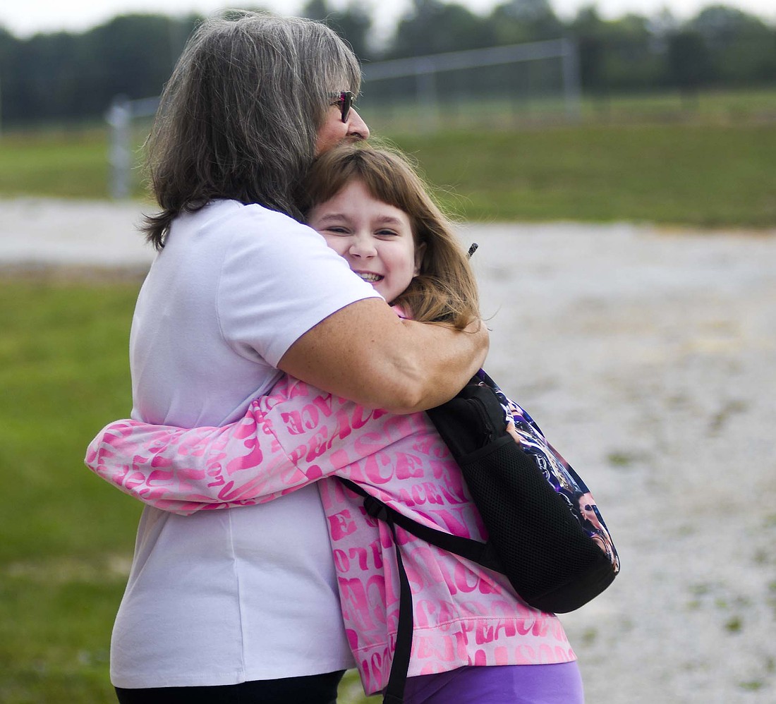Fourth grader Callie Shaneyfelt hugs resource teacher Jennifer Rupe upon arriving for  school Thursday morning at West Jay Elementary School in Dunkirk. Thursday marked the first day of classes for the 2024-25 school year for Jay School Corporation. (The Commercial Review/Ray Cooney)
