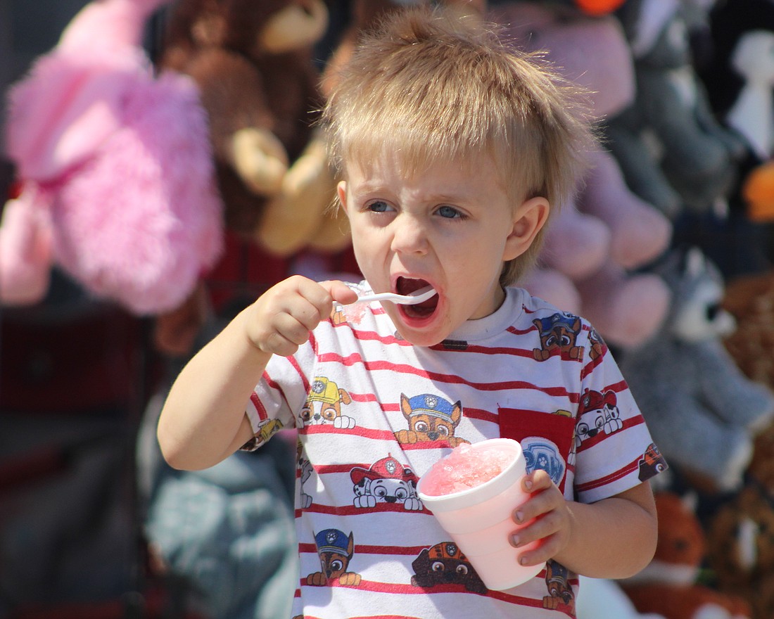 Ryan Moser, 3, eats a spoonful of snow cone Saturday along High Street in Redkey during Gas Boom Days festivities. The event Saturday and Sunday included a parade, a variety of concerts, vendors, food and other activities. (The Commercial Review/Bailey Cline)