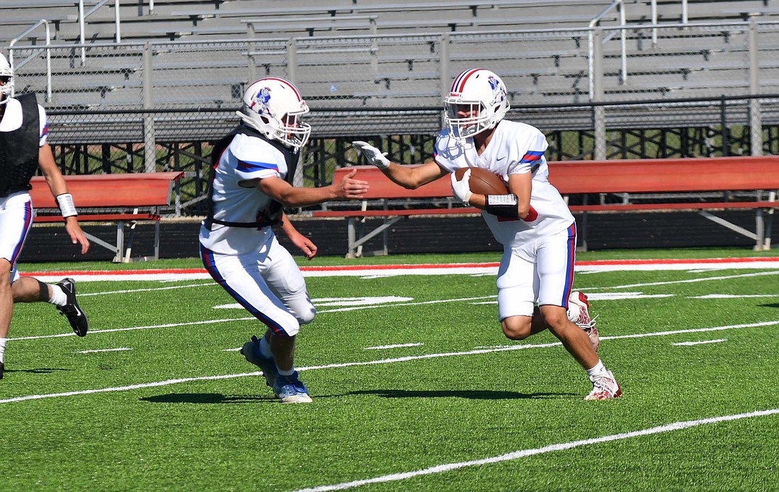 Jay County High School junior Grant Wendel prepares to stiff arm his defender during the JCHS football team’s red and white scrimmage on Saturday morning. The Patriots will face New Castle week two in their home opener on the new turf field on Aug. 30. (The Commercial Review/Andrew Balko)