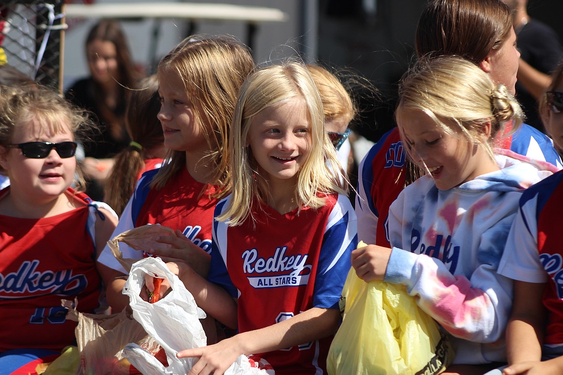 Redkey All Stars team members sort through bags of candy before tossing them to parade watchers near the intersection of Railroad and High streets Saturday during the Gas Boom Days festival. Local festivals continue this weekend with Dunkirk’s Glass Days scheduled for Saturday. (The Commercial Review/Bailey Cline)