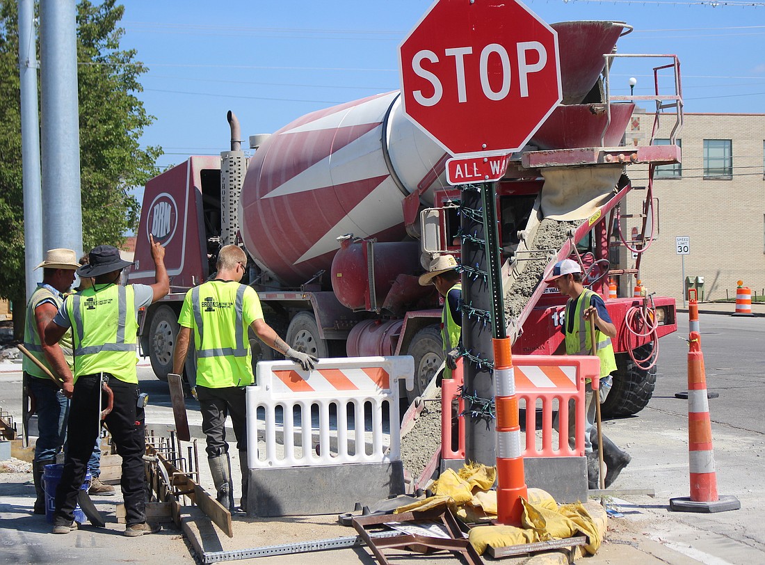 Brooks Construction workers pour concrete into a base for a sidewalk curb Wednesday at the southwest corner of Main and Meridian streets in Portland. The work is part of an ongoing Indiana Department of Transportation project that includes installing bump-outs at some downtown intersections. (The Commercial Review/Bailey Cline)