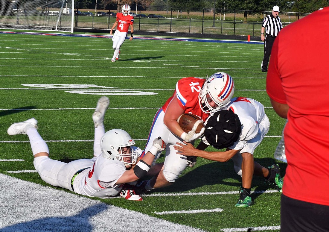 Garrett Bennett of the Jay County High School football team fights to stay in bounds and upright while a pair of Richmond defenders try to take him down during Friday’s scrimmage. The Patriots have six days before the 2024 season opens up at Blackford on Friday. (The Commercial Review/Andrew Balko)