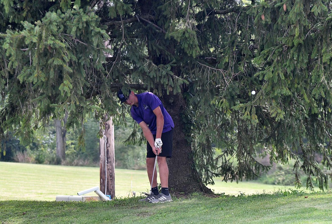 Fort Recovery High School senior Keegan Muhlenkamp chips out from under a tree on the 15th hole at Portland Golf Club on Thursday. Muhlenkamp shot a 42 as the Indians took down Parkway 161-172. (The Commercial Review/Andrew Balko)