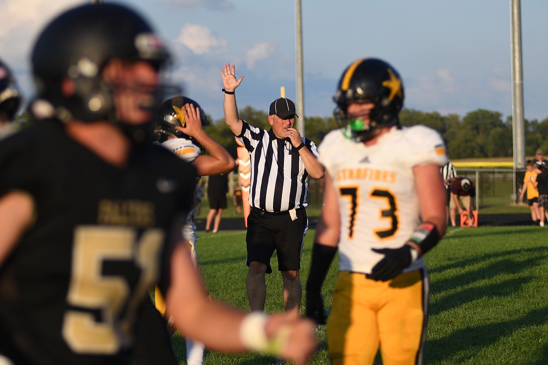 Bill Back of Dunkirk signals Friday night during the scrimmage between South Adams and host Winchester. Regular-season football in Indiana kicks off next weekend. (The Commercial Review/Ray Cooney)