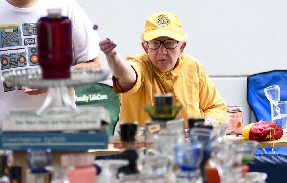 Sylvia Shawver of Portland takes her chances at the American Legion nickel toss at Dunkirk['s Glass Days festival Saturday. The event, in its second year after a hiatus from 2020 through 2022, also featured a breakfast, 5K, glass factory tours, food, a push-up contest, a cornhole tournament, kids games and activities, a celebration of Cinderella Queen of Glass, a pet parade, a fish fry, a golf cart parade, a car show, an artisan glass auction and a concert with Cook & Belle. (The Commercial Review/Ray Cooney)