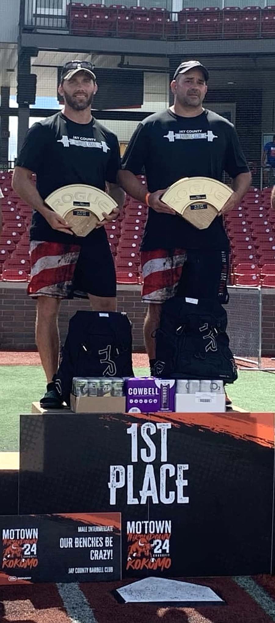 Kurt Hess (left) and Heath Alexander of Jay County Barbell Club stand atop the podium after claiming first place in the men’s intermediate division of the Mo’Town Throwdown CrossFit Competition at Kokomo on Saturday. Teams from Indiana, Ohio and Illinois participated in the event. (The Commercial Review/Andrew Balko)