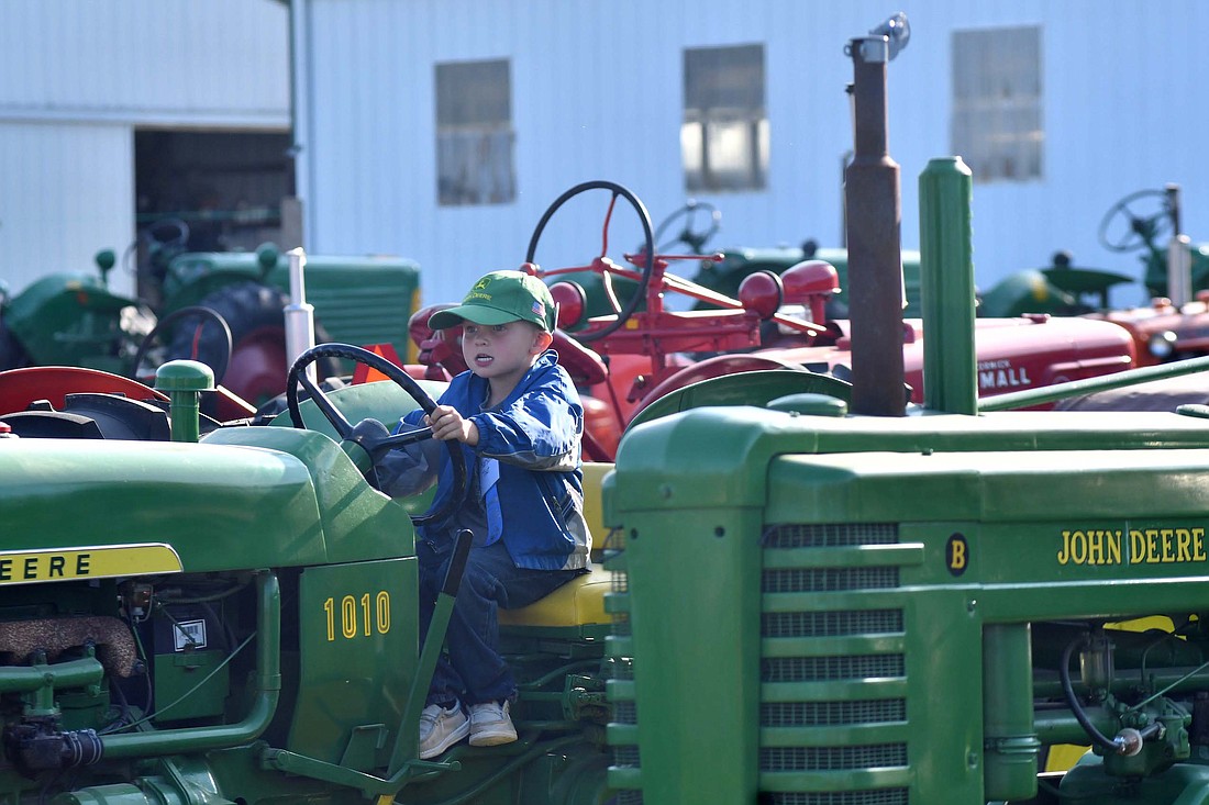 Karsen Tout, 5, gets behind the wheel of a John Deere 1010 on Wednesday afternoon at the Tri-State Gas Engine and Tractor show. This year marks the 59th iteration of the annual event that has participants from across the nation, Canada and around the world. (The Commercial Review/Andrew Balko)