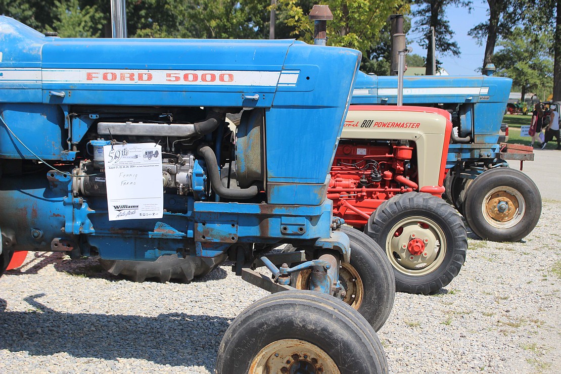 A line of antique Ford tractors sit on display Friday afternoon at the fairgrounds. (The Commercial Review/Bailey Cline)