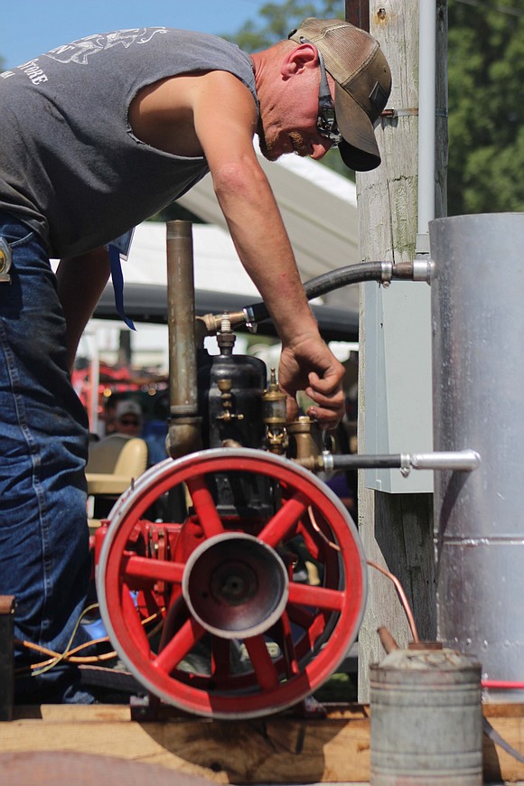 Jeremy Knapschafer of Bryant works on his 1909 Detroit engine. Knapschafer has attended the show for more than 20 years, and his father, Portland resident Joe Knapschafer, has joined him for the last dozen years. (The Commercial Review/Bailey Cline)