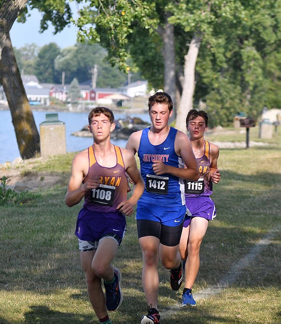 JCHS junior Max Klopfenstein runs along with two Bryan runners during the Celina Rotary Invite on Saturday. Klopfenstein finished 58th with a time of 20 minutes, 1.7 seconds, in his first race of the year. (The Commercial Review/Andrew Balko)