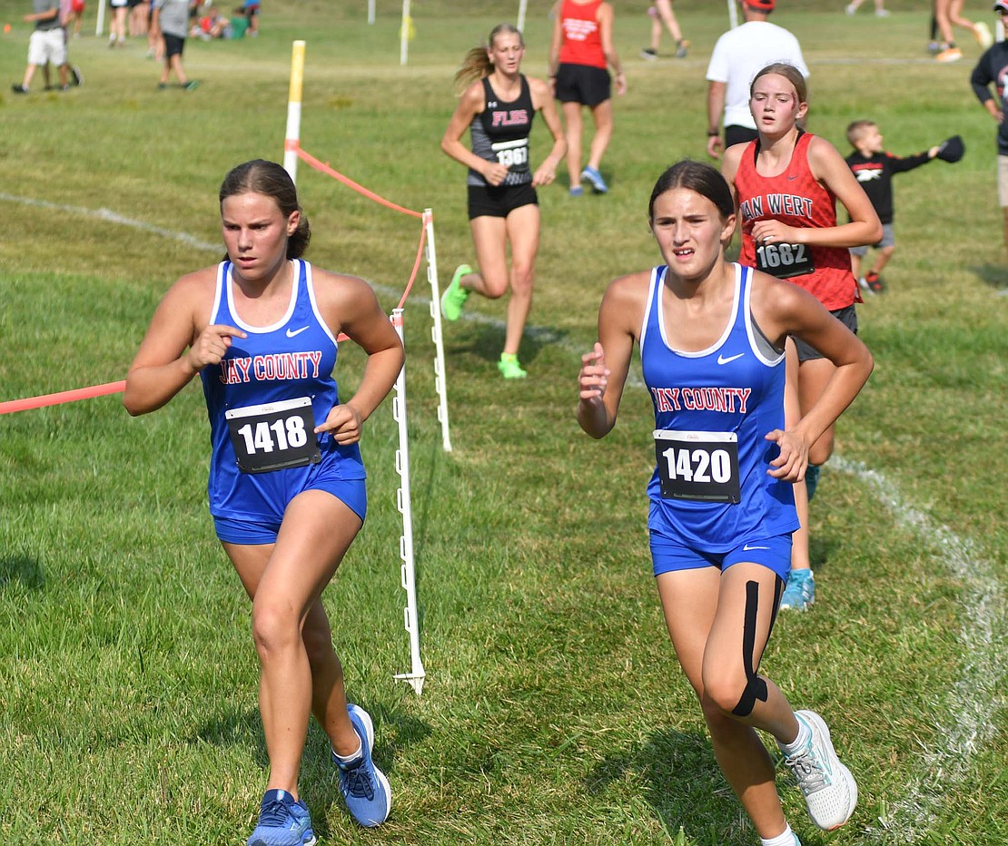 Jay County High School freshmen Brooklynn Byrum (left) and Jessie Homan run together midway through the third mile of the Celina Rotary Invitational at Wright State University – Lake Campus Saturday. The pair led the Patriots with 14th and 18th-place finishes, respectively. (The Commercial Review/Andrew Balko)