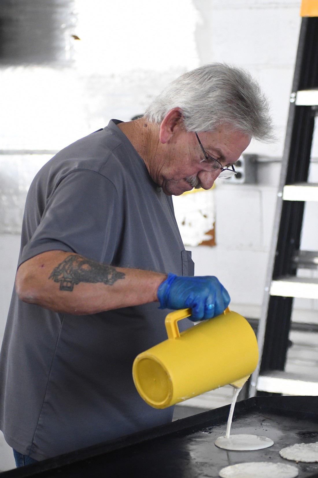 Danny Ingram pours pancake batter onto a griddle during the Portland Municipal Airport pancake breakfast and fly-in Saturday morning. The event was a partnership between the airport and the American Legion Riders. (The Commercial Review/Ray Cooney)