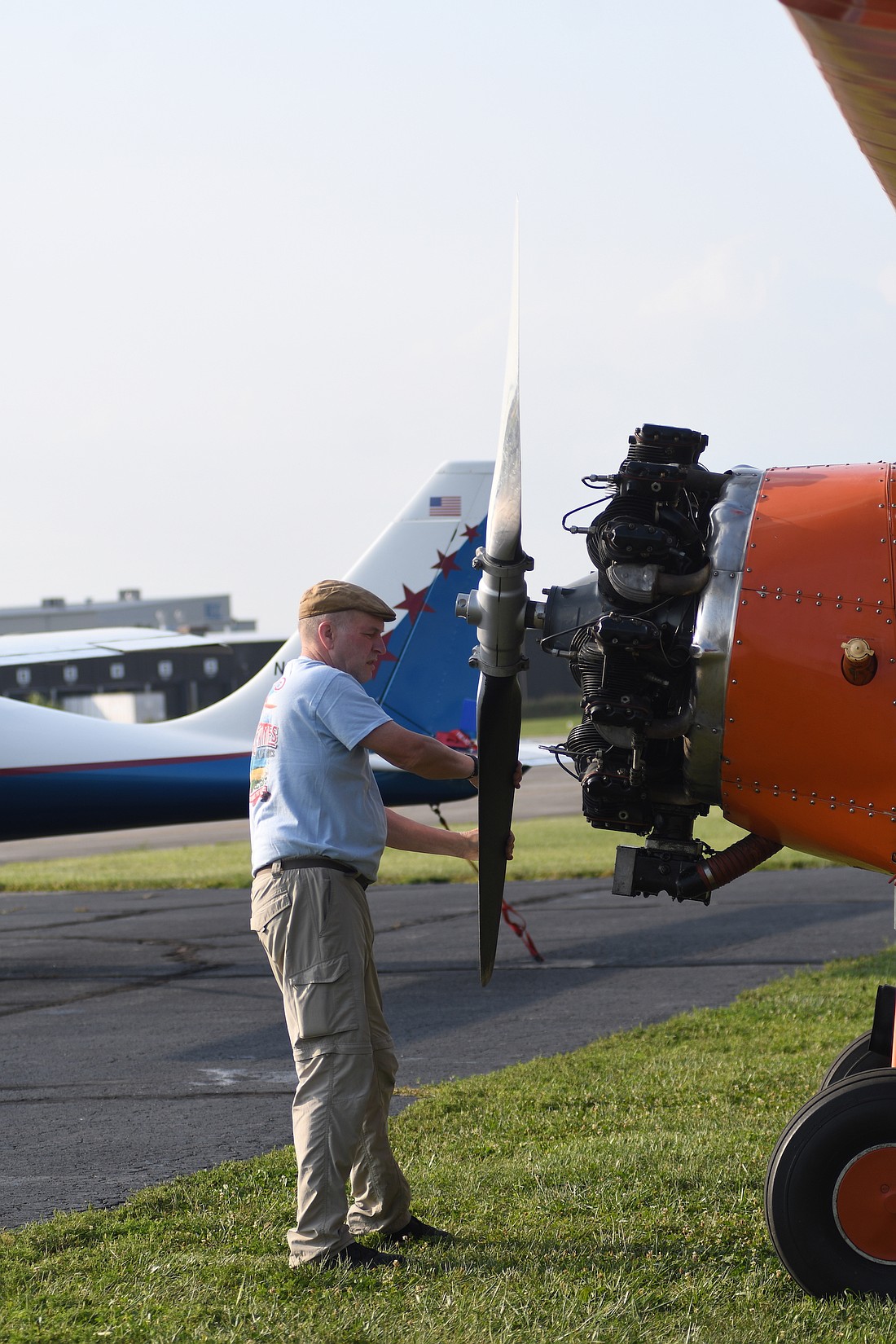 Andrew King of Goodfolk & O’Tymes Biplane Rides spins a propeller Saturday morning while checking an aircraft before flying at the Portland Municipal Airport pancake breakfast and fly-in. Goodfolk offered rides in pre-World War II era planes on Thursday, Friday and Saturday. (The Commercial Review/Ray Cooney)