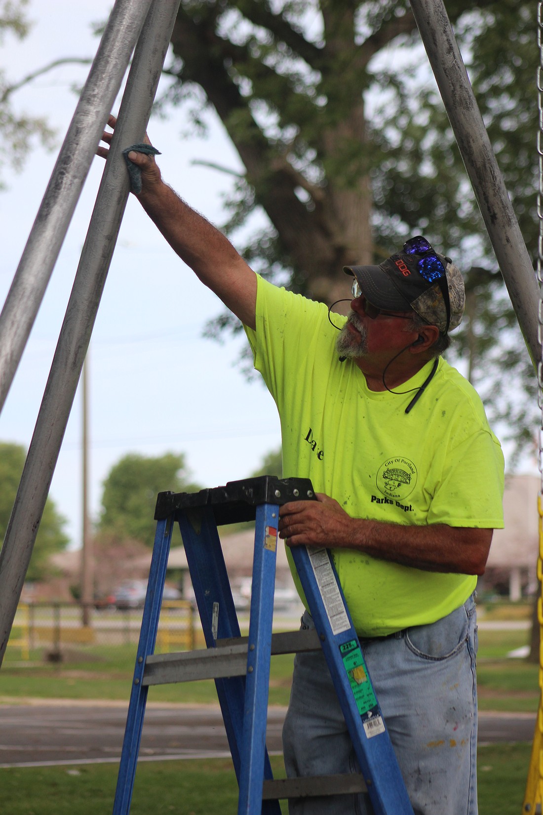 Dave Stoner, a part-time employee with Portland Parks Department, prepares a swing set at Haynes Park for a fresh coat of paint Wednesday. (The Commercial Review/Bailey Cline)