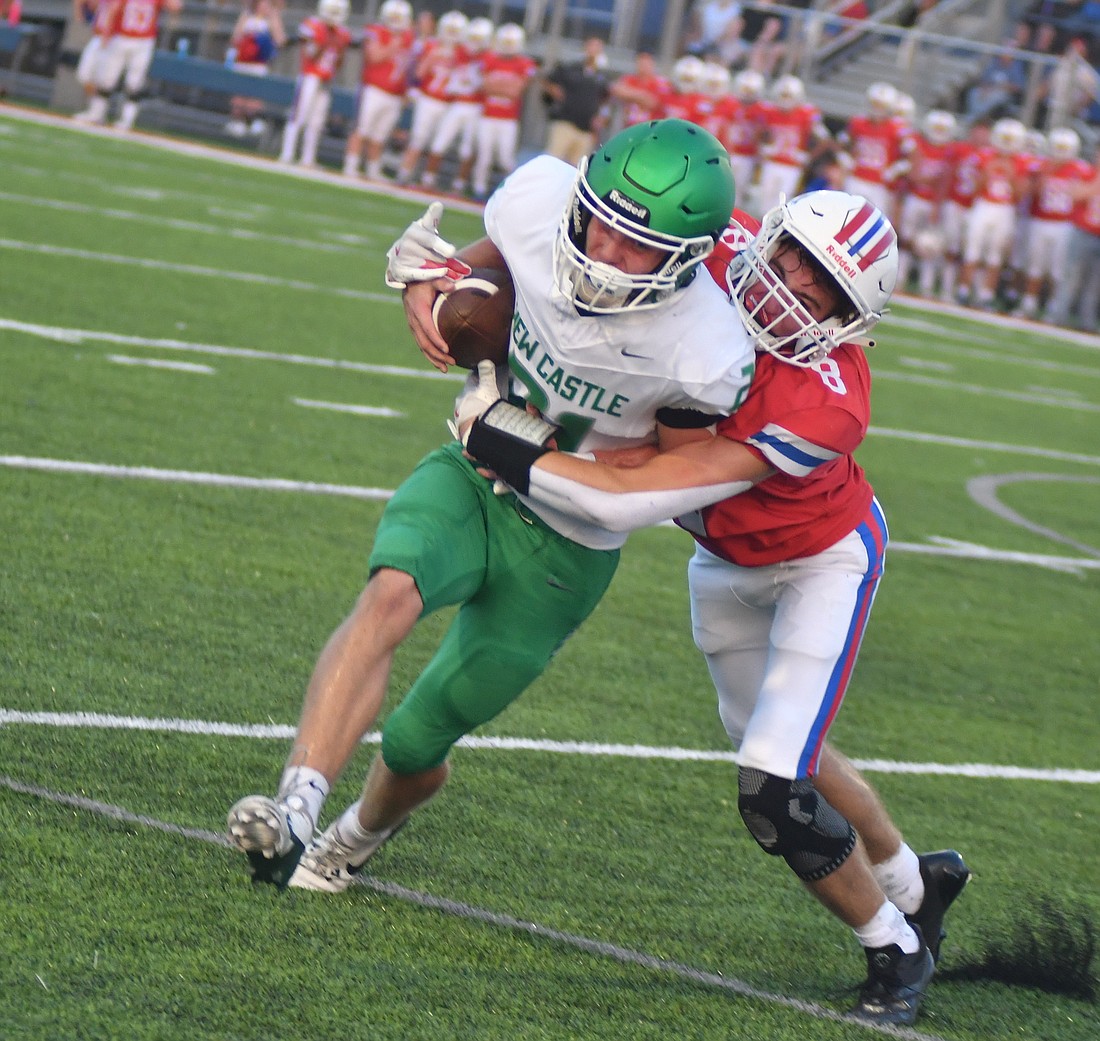 Jay County High School’s Carter Fugiett tackles New Castle’s Cade Logston on a 2-point attempt in the second quarter on Friday night. While the Patriots stopped the 2-point play, they couldn’t stop the Trojans from getting three touchdowns before play was stopped for lightning and the Patriots conceded. (The Commercial Review/Andrew Balko)