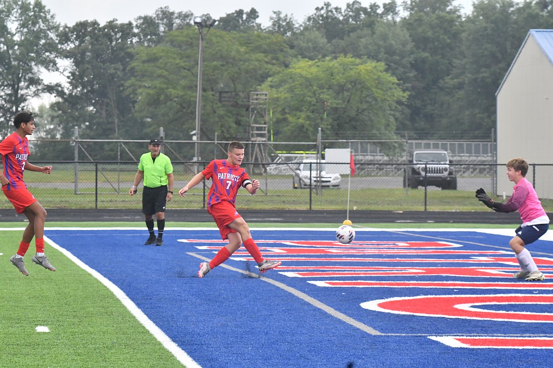 Levi Muhlenkamp of the Jay County High School boys soccer team gets a shot past Woodlan goalkeeper Justin Fiedler during the Patriots 4-3 win on Saturday. The senior’s second hat trick in three days proved important as the Warriors second-half surge fell short. (The Commercial Review/Andrew Balko)