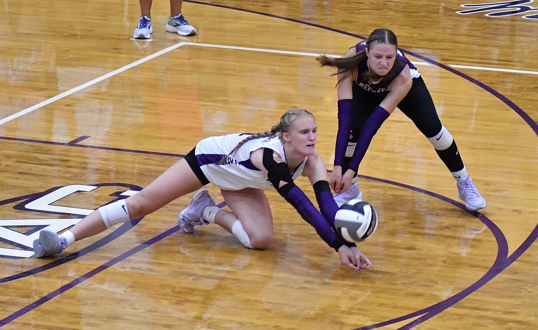 Kennedy Muhlenkamp (left) and Kenna Dues dig out a ball during the Indians’ 25-14, 28-26, 25-20 win over Jay County on Tuesday. Dues dominated the match with seven aces and 21 digs, while Muhlenkamp supported with five kills and two blocks. (The Commercial Review/Andrew Balko)