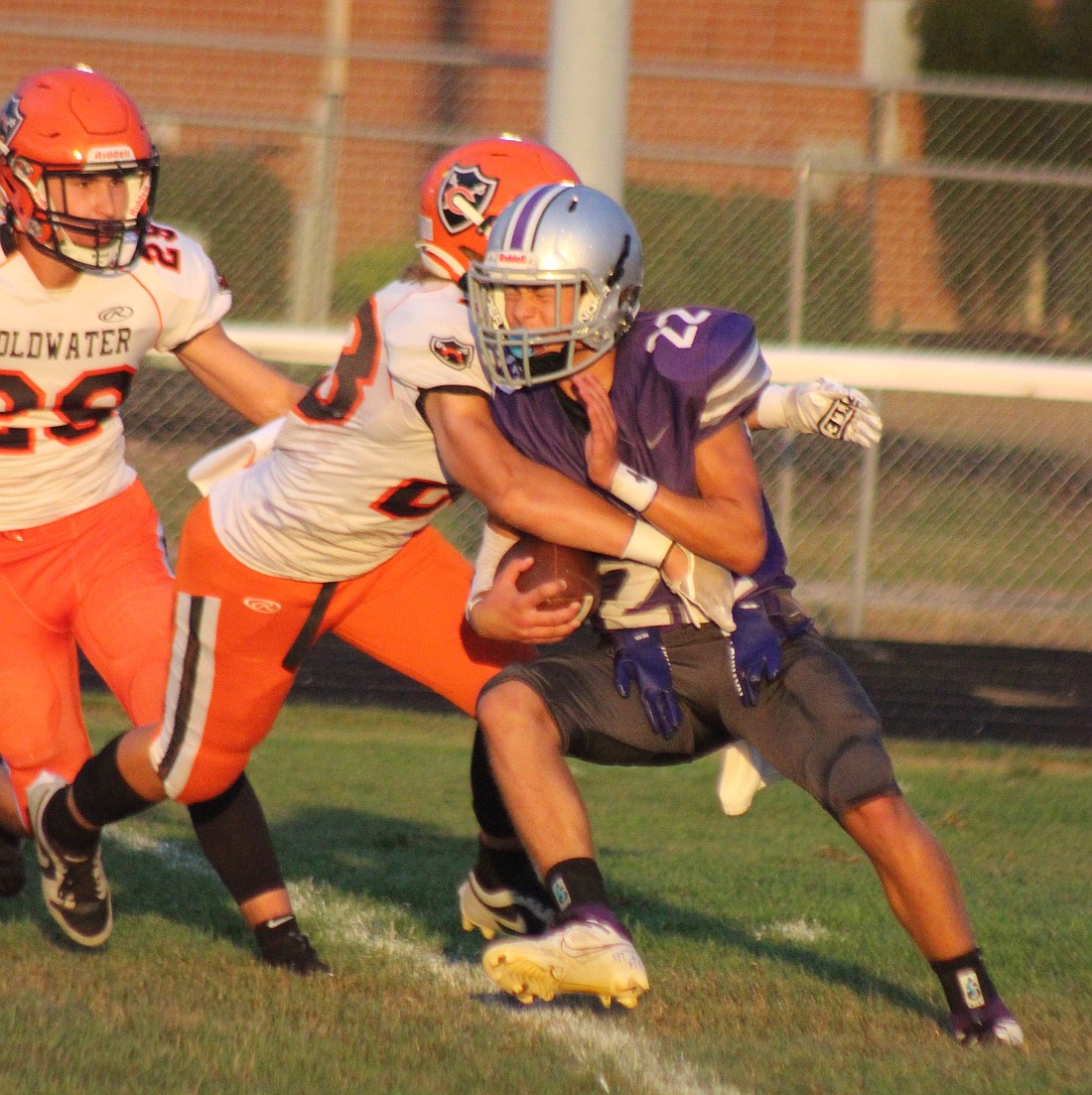 Brodie Hart of Fort Recovery High School gets wrapped up by Derek Dues (23) while returning a kick Friday night during the Indians’ 55-8 loss to Division VI No. 1 Coldwater. The loss dropped FRHS to 1-2. (The Commercial Review/Bailey Cline)