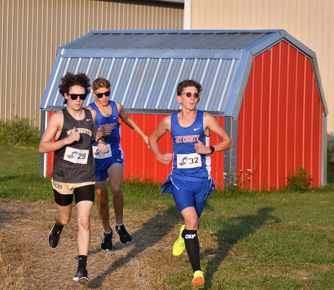 Jay County High School’s Caleb Garringer (32) leads Winchester’s Hunter Patterson and teammate Dash Thacker early in the meet on Tuesday. Garringer had the top time of 17 minutes, 34.55 seconds, to lead JCHS to an 18-40 victory. (The Commercial Review/Andrew Balko)