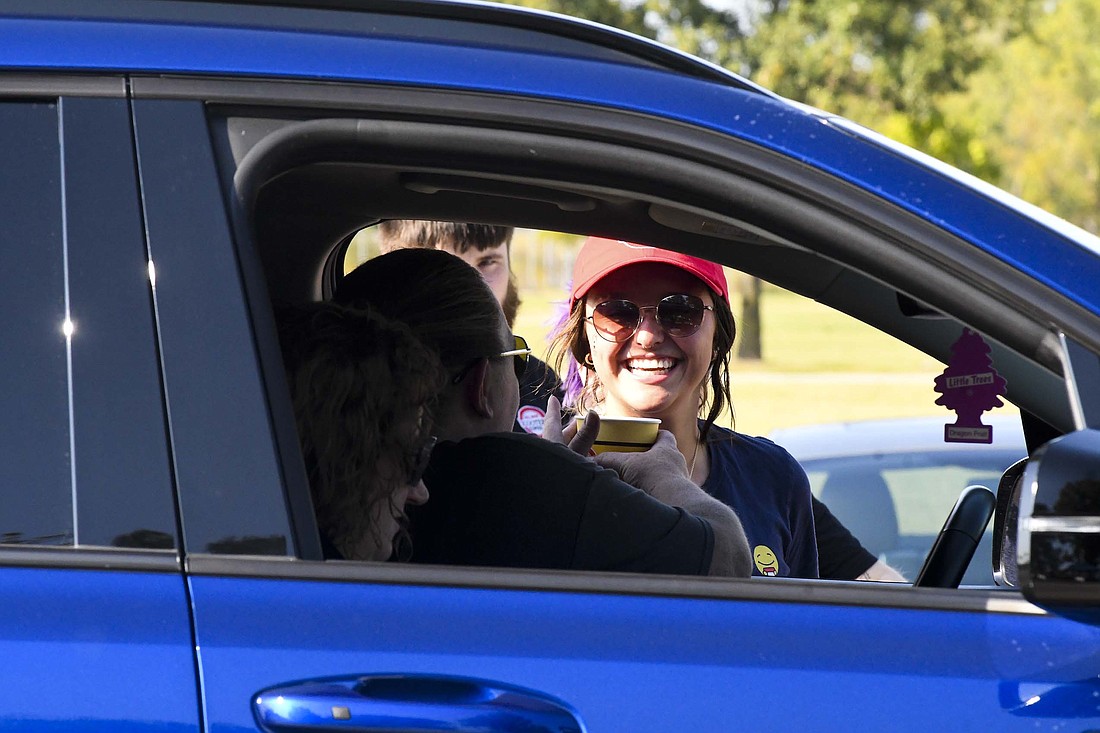 Macy Miller of Scooter’s grins while handing out a cup of lemonade during the Jay County Cancer Society Cruise-In on Saturday at Jay County Fairgrounds. Cancer survivors drove through receiving items from the cancer society as well as various local businesses, churches and other organizations. (The Commercial Review/Ray Cooney)