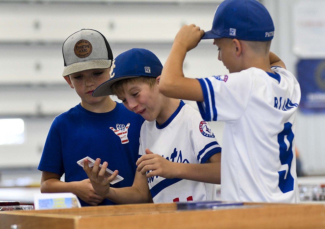 Khoden Bentz reacts while looking at a card along with Jase Lewellen (left) and Oaklin Blunk (right) on Saturday during the Jay County Fair Cards Coins Comics and Collectibles Show in the Bubp Building at Jay County Fairgrounds. The next show is scheduled for 10 a.m. to 4 p.m., Saturday, Oct. 19, at the fairgrounds. (The Commercial Review/Ray Cooney)