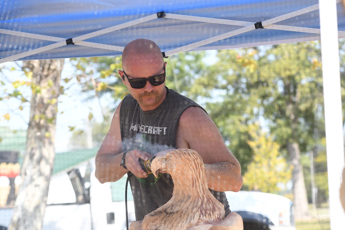 Chaz Chiafos of Indiana works on the eye of an eagle on Saturday afternoon during the Jay County Chainsaw Carving Invitational and Vendor Fair. Chainsaw artists from Indiana, Kentucky, Iowa, Delaware, Kansas and South Carolina worked Friday, Saturday and Sunday on carvings, which were then sold at auction on Sunday afternoon. (The Commercial Review/Ray Cooney)